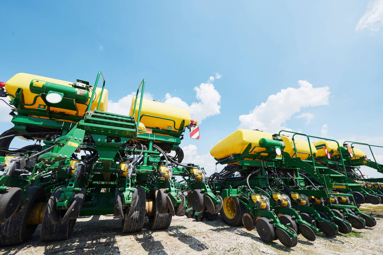Close up of seeder attached to tractor in field. Agricultural machinery for spring works sowing, seeding